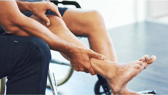 Person in a wheelchair having their leg held and examined by another person image