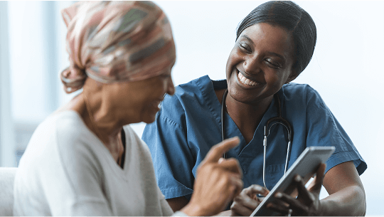 Woman with a headscarf, next to a smiling healthcare professional image
