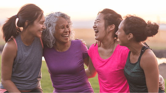Women sat down outside laughing together image