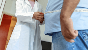 Healthcare professional measuring the waist of an overweight man image