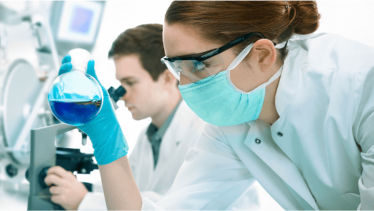Laboratory worker examining glass beaker image