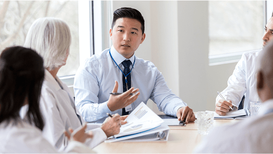 Healthcare professionals in discussion around a table image