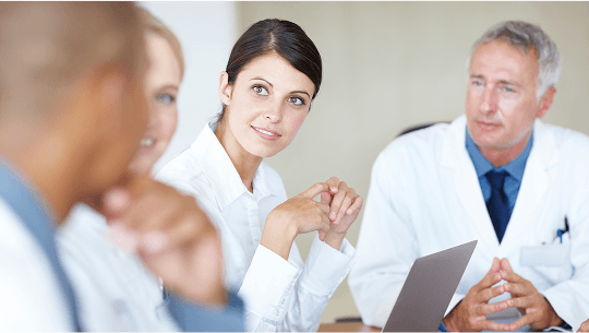 Healthcare professionals in discussion around a table image