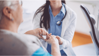 Healthcare professional holding the hands of an elderly woman image