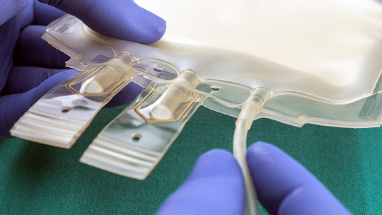 Person with gloves on, handling a feeding bag image