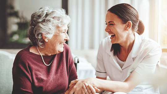 Elderly lady and young lady looking at eachother laughing image