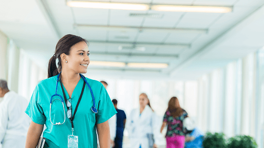 Healthcare professional walking down a busy hospital corridor image