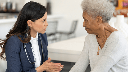 Healthcare professional sat down with a female patient, having a conversation image