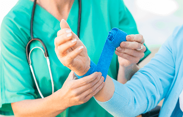 Healthcare professional bandaging up a patient's wrist image