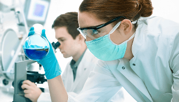 Laboratory worker examining glass beaker image