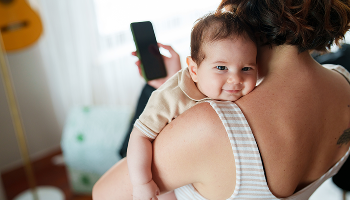 Baby being held over a woman's shoulder