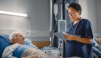Elderly man in hospital bed being checked by a healthcare professional image