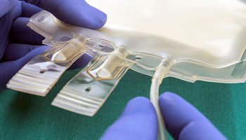 Person with gloves on, handling a feeding bag image