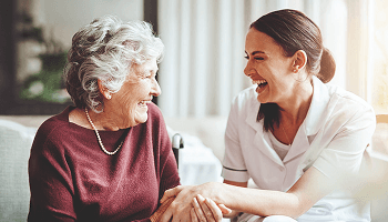 Elderly lady and young lady looking at eachother laughing image