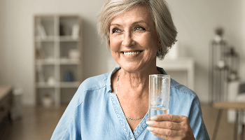 Woman smiling and holding an empty glass image