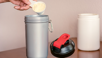 A scoop of powder being poured into a shaker image