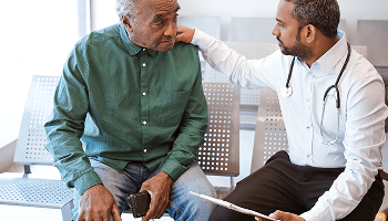Elderly man and doctor sat down image