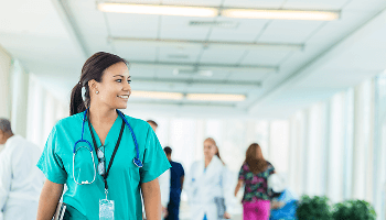 Healthcare professional walking down a busy hospital corridor image