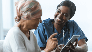 Woman with a headscarf, next to a smiling healthcare professional image