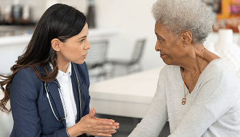 Healthcare professional sat down with a female patient, having a conversation image