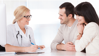 Healthcare professional having a conversation with a young couple at a desk image