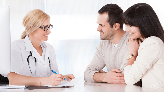 Healthcare professional having a conversation with a young couple at a desk image