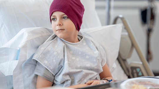 Child waering a head scarf in a hospital bed image