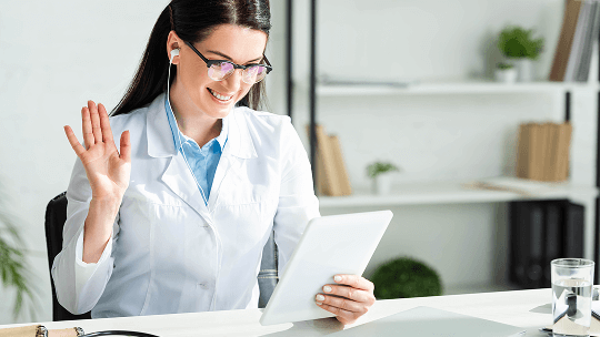 Healthcare professional having a video call at her desk using a tablet device image