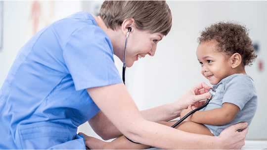 Healthcare professional examining a young, smiling child with a stethoscope image