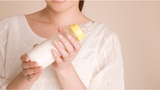 Woman holding a full baby bottle image
