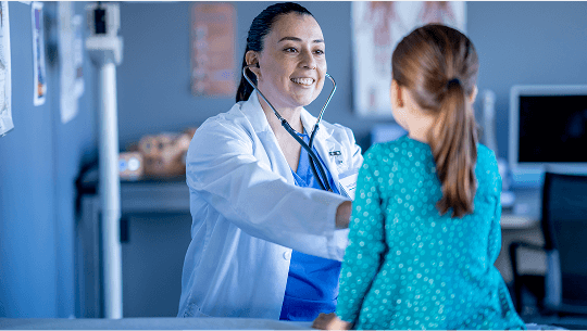 Healthcare professional examing a child in a hospital image