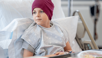 Child waering a head scarf in a hospital bed image