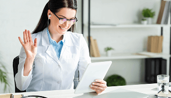 Healthcare professional having a video call at her desk using a tablet device image