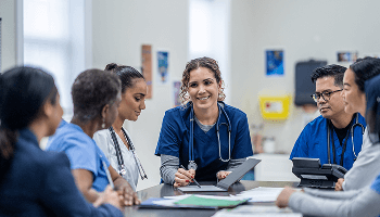 Healthcare professionals in discussion around a table image