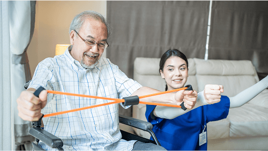 Elderly man doing band exercises using his arms whilst sat in a wheelchair image