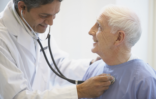 Elderly man being examined by a doctor using a stethoscope image